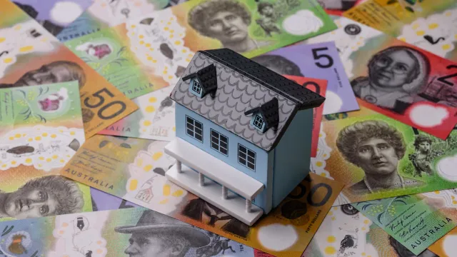 A model house sits on a pile of Australian dollar notes.
