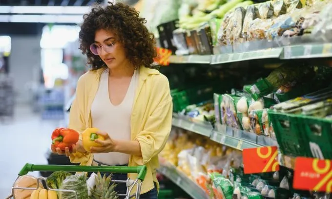 Woman deciding between fruits in a supermarket.jpg