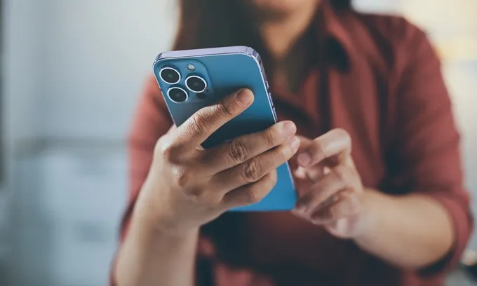 Woman looking at phone comparing mobile plans