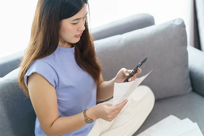 Woman on mobile phone checking bill