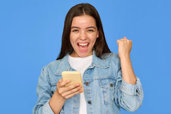 Happy young woman holding mobile phone