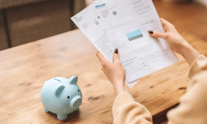Woman with piggy bank paying bills. Electricity price changes