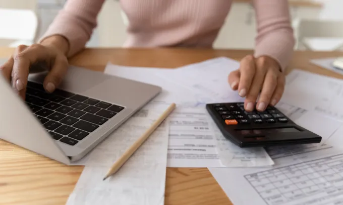 A woman calculating the cost of her home loan’s fees