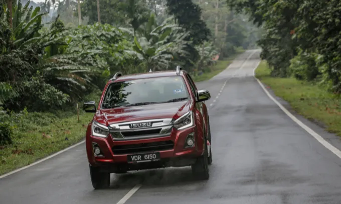 Isuzu D-Max driving down a tropical road