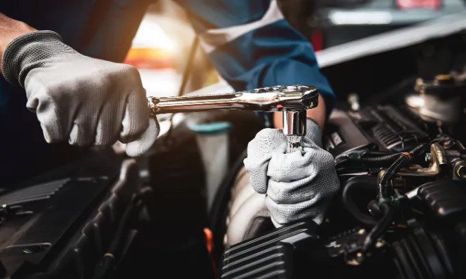 Mechanic using a spanner on a car engine