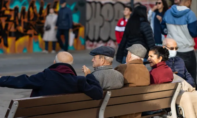 Four elderly people sitting on a bench